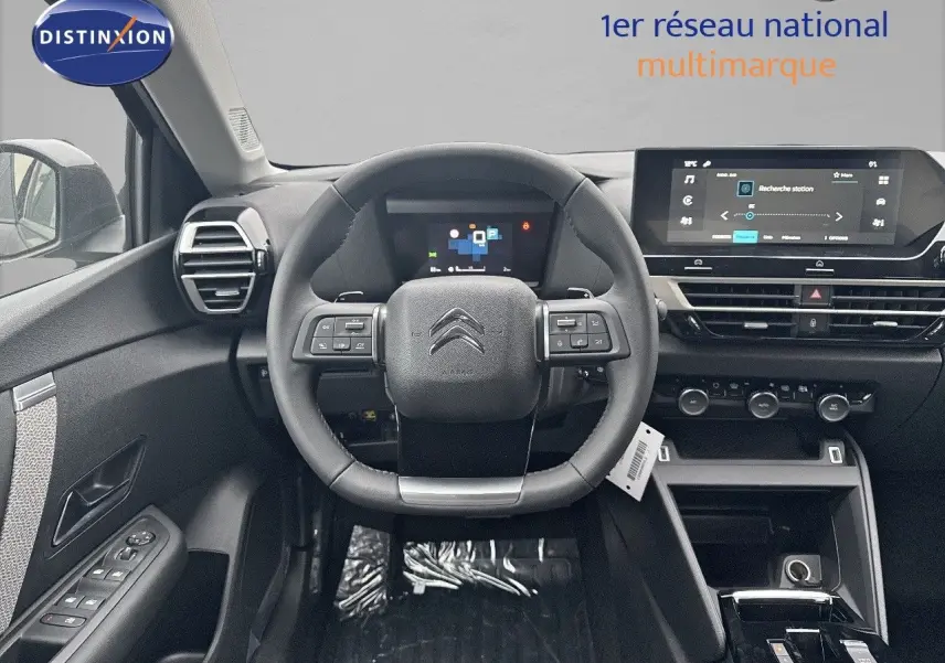 Intérieur noir de la Citroën C4 2024, vue frontale du poste de conduite avec volant multifonction et écran tactile.