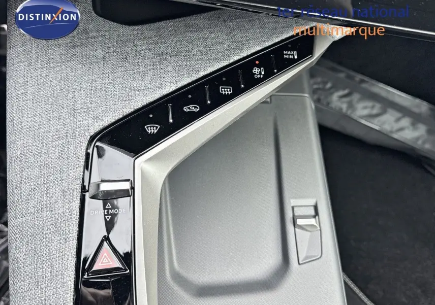 Gros plan sur la console centrale du Peugeot 3008 Hybrid 2025, mettant en valeur les commandes tactiles et le bouton de mode de conduite.