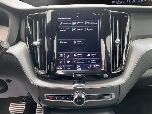 Vue rapprochée du tableau de bord noir du Volvo XC60 2021, mettant en valeur l'écran tactile central et les commandes intégrées.
