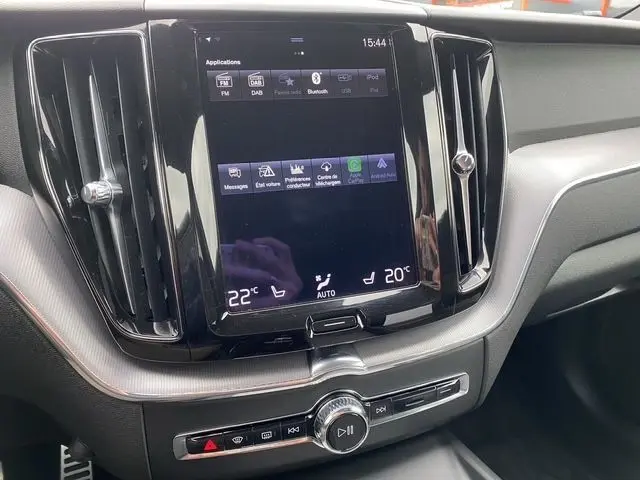 Écran tactile central et commandes de climatisation du tableau de bord d'un Volvo XC60 noir, version R-Design 2021.