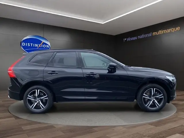 Profil côté gauche d'un Volvo XC60 noir 2021 R-Design avec toit panoramique, roues alliage et lignes élégantes.