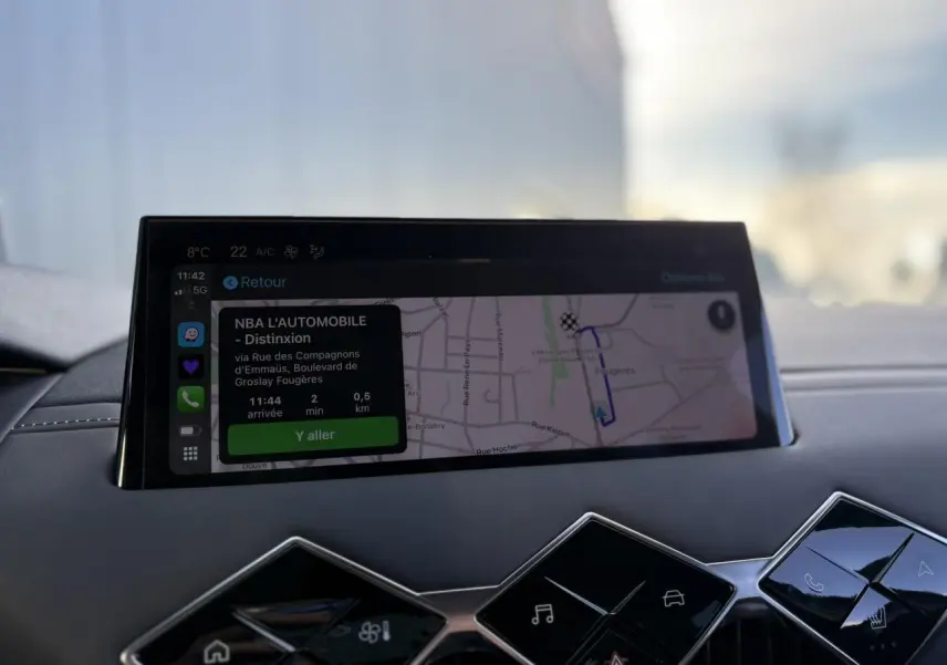 Vue intérieure du tableau de bord du DS3 2024 avec écran tactile affichant la navigation et commandes tactiles en losange noir brillant.