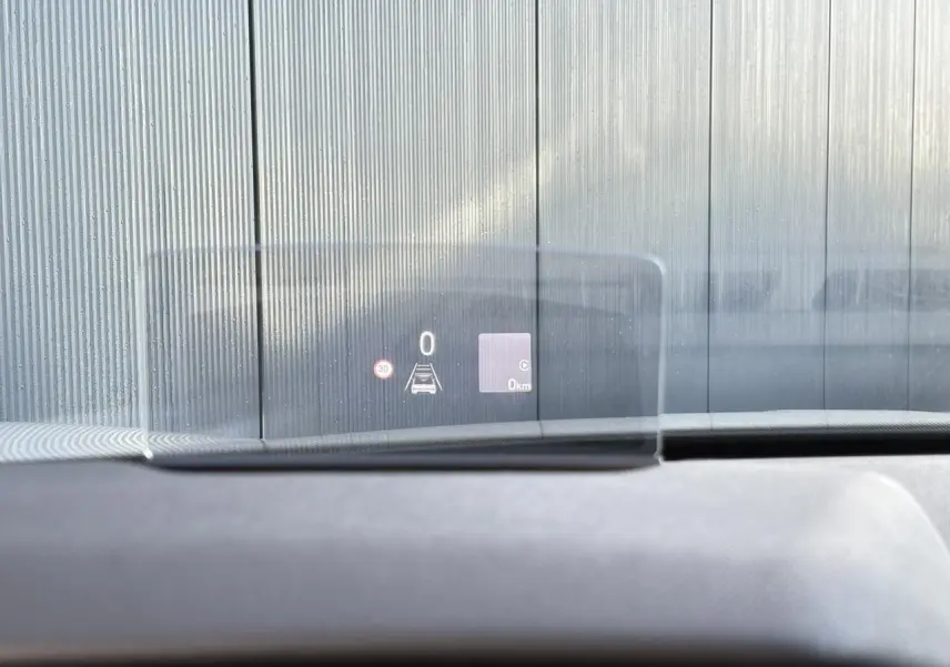 Affichage tête haute transparent du tableau de bord d'une DS3 2024, vue intérieure avant, avec indication de vitesse et alertes.