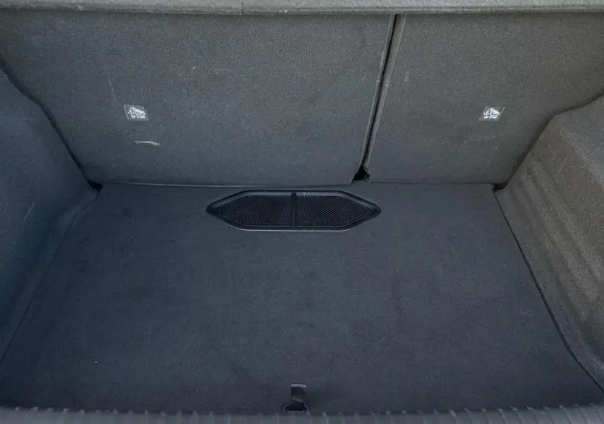 Vue intérieure du coffre spacieux et tapissé en tissu gris foncé du DS3 2024 bi-ton gris Artense et noir.