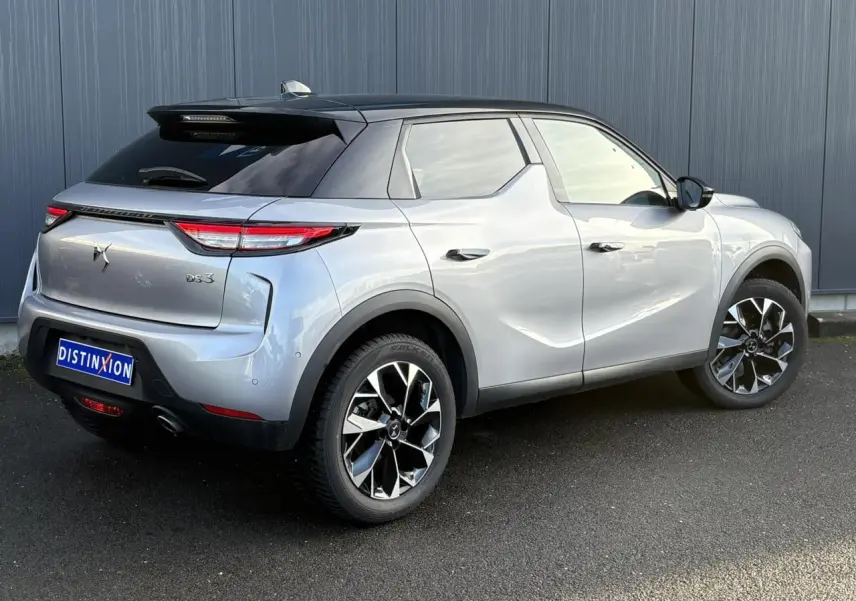 Vue 3/4 arrière droite du DS3 2024 gris Artense avec toit noir et jantes alliage 18 pouces distinctives.