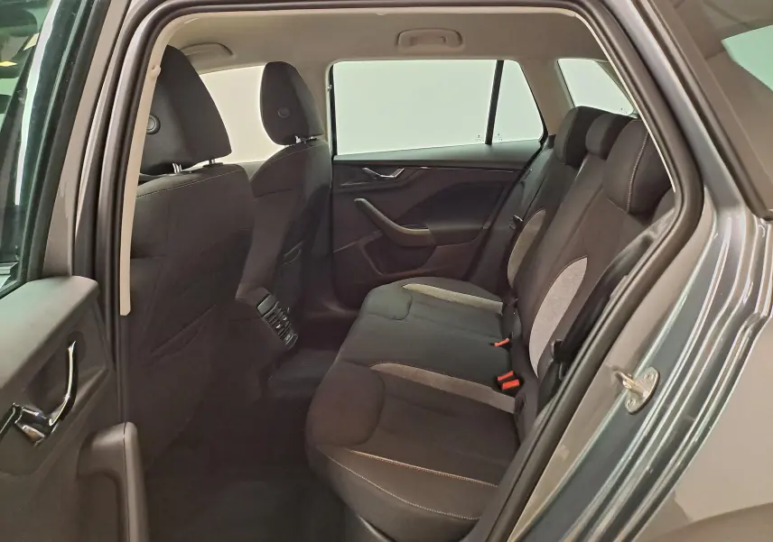 Vue intérieure arrière côté gauche du Skoda Kamiq gris graphite, montrant les sièges arrière en tissu bi-ton.