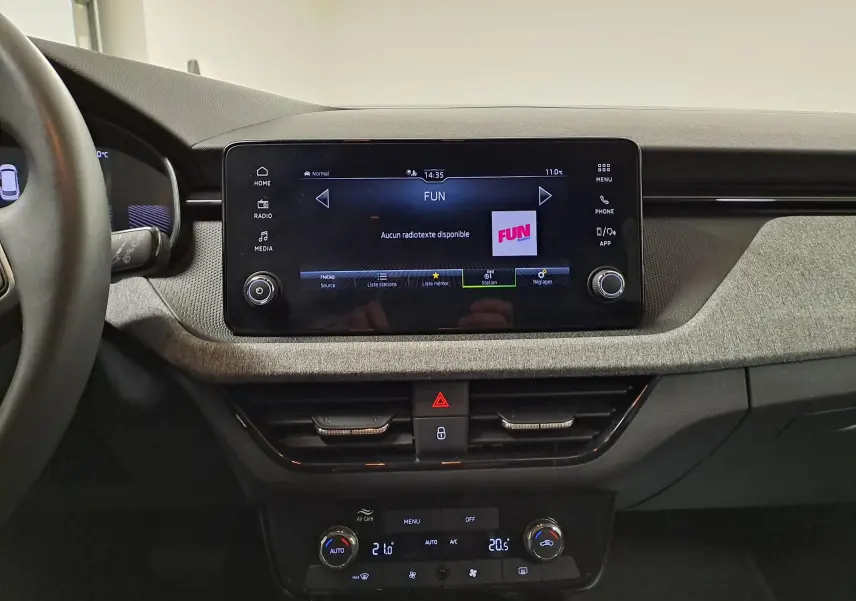 Intérieur du Skoda Kamiq 2025, vue centrale sur l'écran tactile et la console, finition gris graphite avec commandes digitales.