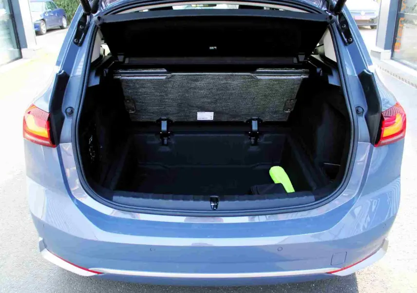 Coffre ouvert vu de l'arrière d'une BMW Série 2 Active Tourer gris Nardo métal, avec un objet vert à l'intérieur.
