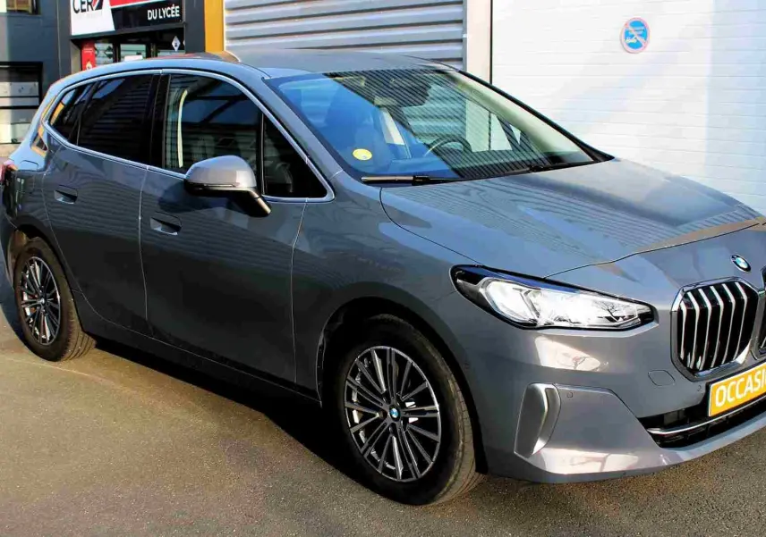 BMW Série 2 Active Tourer gris Nardo métal vue 3/4 avant droit avec calandre imposante et jantes alliage.