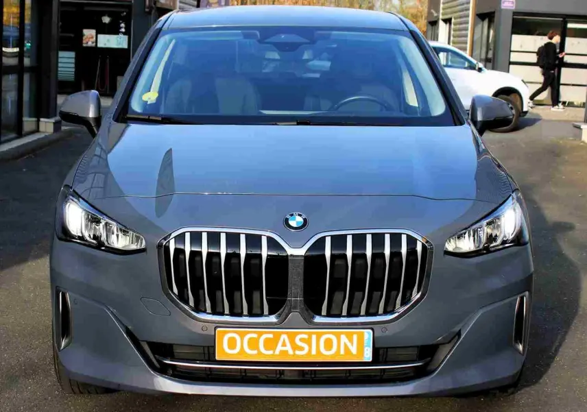 Vue frontale d’une BMW Série 2 Active Tourer gris Nardo métal avec calandre imposante et phares allumés.