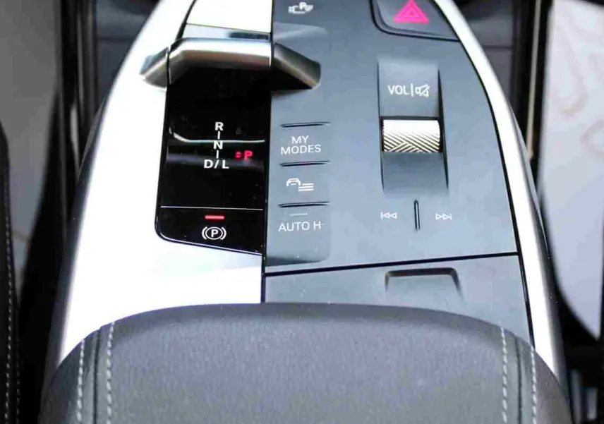 Gros plan sur la console centrale de la BMW Série 2 Active Tourer 218d 2023, avec levier de vitesse et commandes en finition noire et argent.