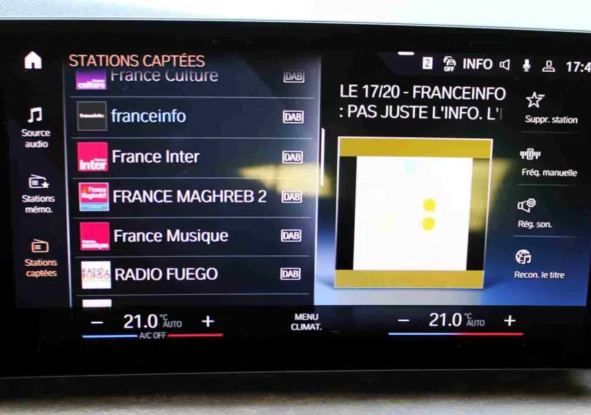 Écran tactile central du BMW Série 2 Active Tourer 218d 2023 affichant les stations radio DAB et la température à 21°C.