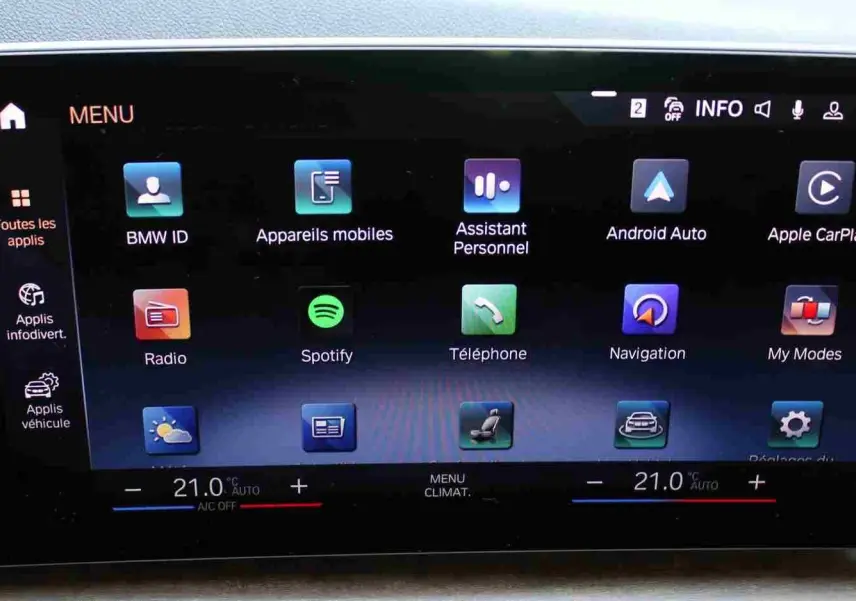 Écran tactile central de la BMW Série 2 Active Tourer 218d 2023 affichant les applications connectées et la climatisation à 21°C.
