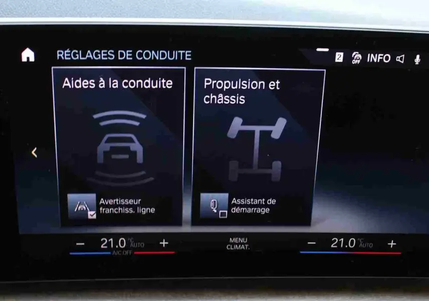 Écran central de la BMW Série 2 Active Tourer 218d 2023 affichant les réglages d’aides à la conduite et propulsion.