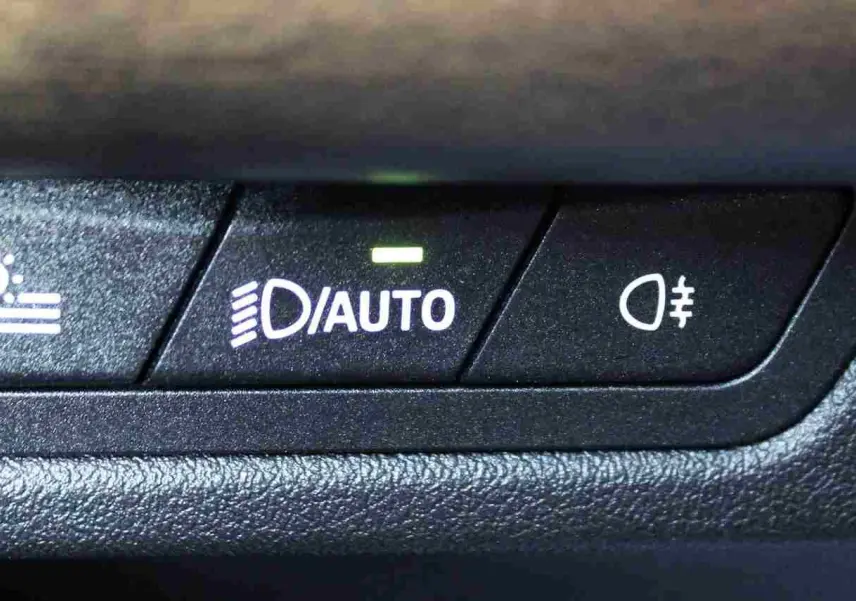 Gros plan sur les boutons de commande des phares automatiques et antibrouillard du BMW Série 2 Active Tourer gris Nardo.