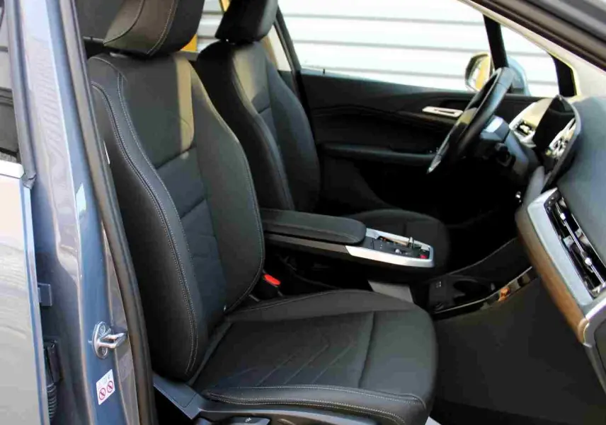 Intérieur côté conducteur de BMW Série 2 Active Tourer gris Nardo, sièges cuir noirs et console centrale moderne.