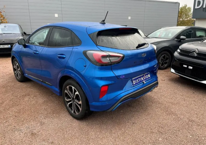 Vue 3/4 arrière droite d'un Ford Puma bleu métallisé avec jantes alliage noires et vitres arrière surteintées.