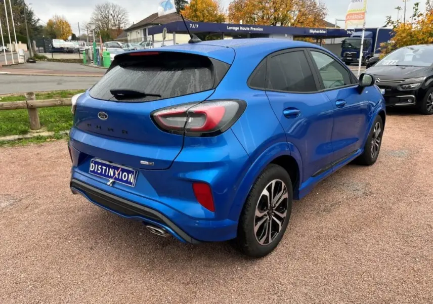 Vue 3/4 arrière droite d'un Ford Puma bleu métallisé avec vitres arrière surteintées et jantes alliage noires.
