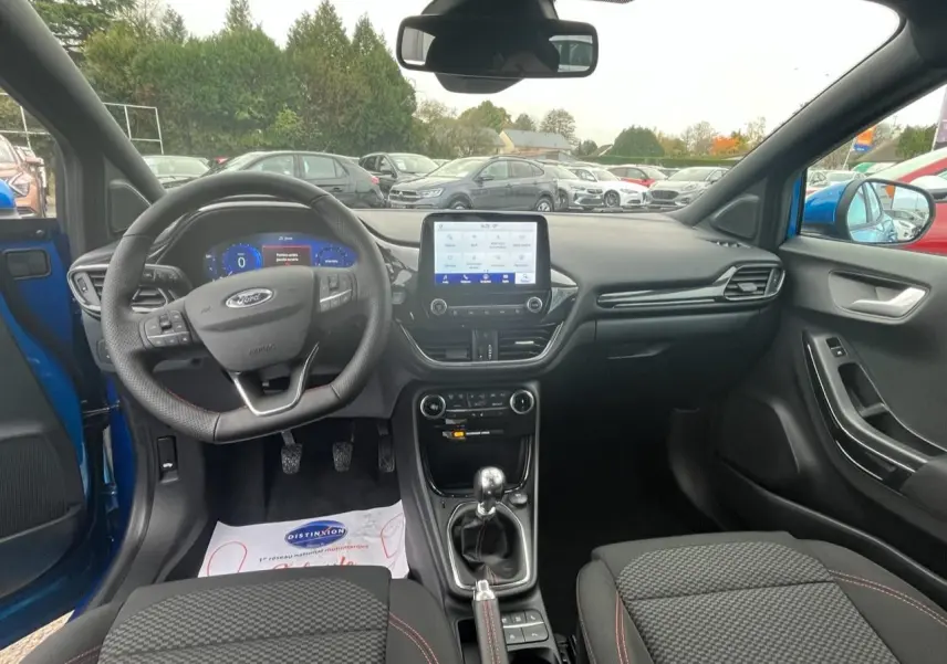Vue intérieure avant du Ford Puma bleu 2022, montrant le tableau de bord, volant multifonction et levier de vitesse manuel.
