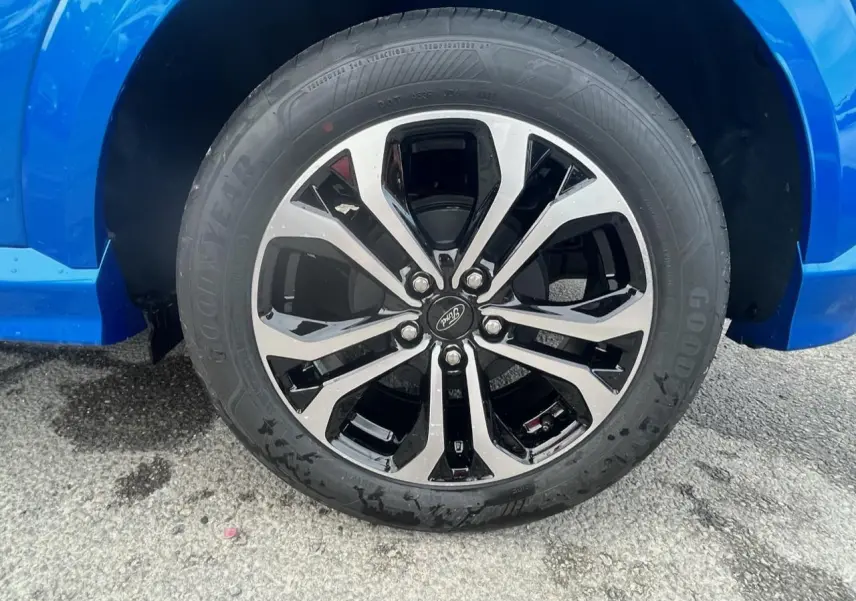 Gros plan sur la jante alliage 17 pouces bicolore noir et argent du côté gauche d’un Ford Puma bleu métallisé.