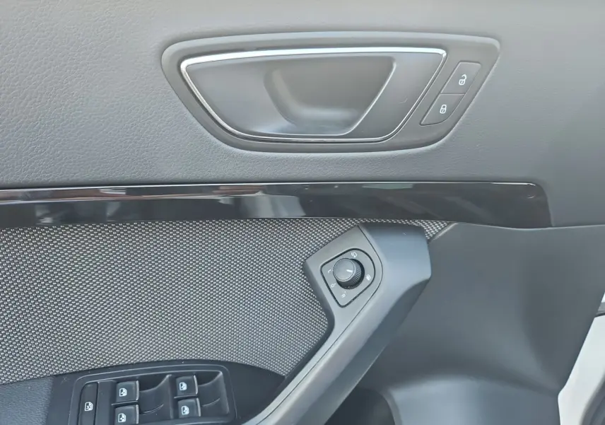 Détail de la porte avant gauche du SEAT Ateca blanc, avec commandes des vitres et réglage des rétroviseurs.