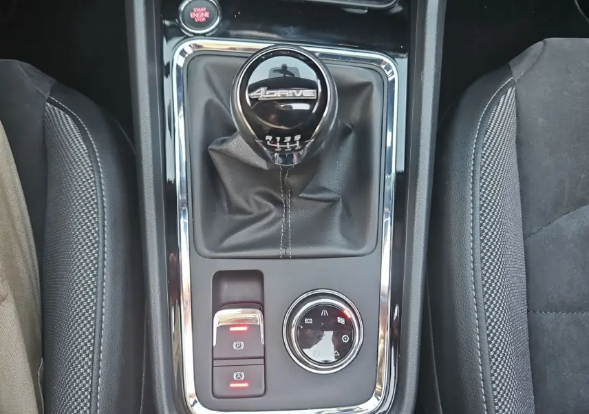Gros plan sur la console centrale du SEAT Ateca blanc, mettant en valeur le levier de vitesses manuel 6 rapports 4Drive.