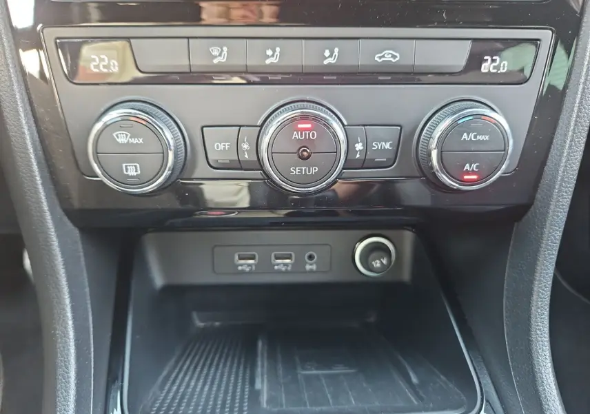 Vue rapprochée du tableau de bord de la SEAT Ateca blanc, montrant la climatisation automatique et ports USB.