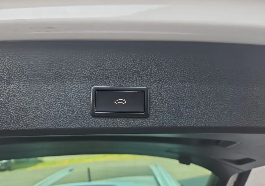 Bouton d'ouverture électrique du hayon sur la partie intérieure du coffre d'un SEAT Ateca blanc.