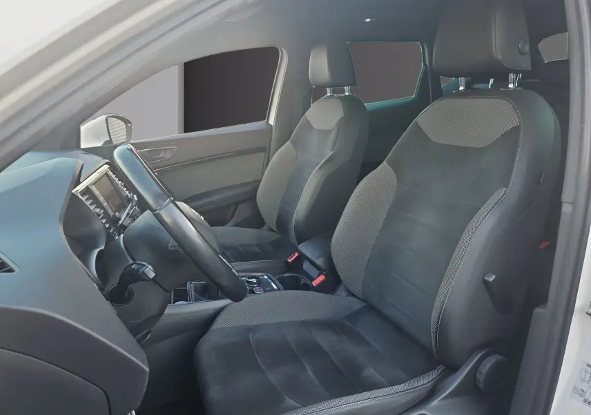 Vue intérieure côté conducteur du SEAT Ateca blanc, mettant en valeur les sièges en cuir et alcantara noirs.