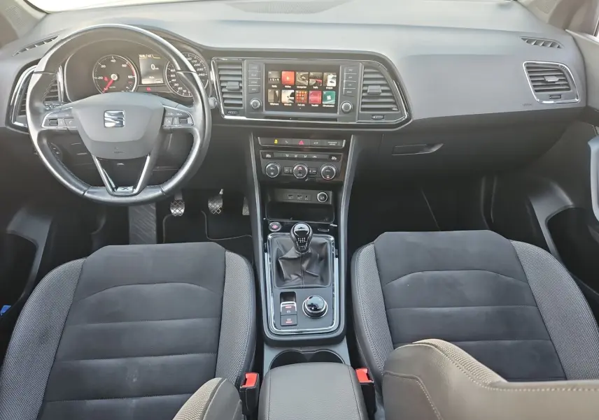 Vue intérieure frontale du tableau de bord et console centrale du SEAT Ateca 2018 avec volant cuir et boîte manuelle.