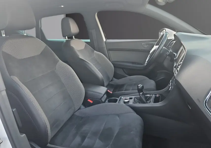 Vue intérieure côté conducteur du SEAT Ateca 2018, sièges cuir et alcantara noirs avec volant cuir et boîte manuelle.