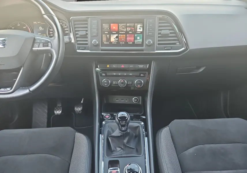 Vue intérieure frontale du tableau de bord et console centrale du SEAT Ateca 2.0 TDI, avec volant cuir et boîte manuelle.
