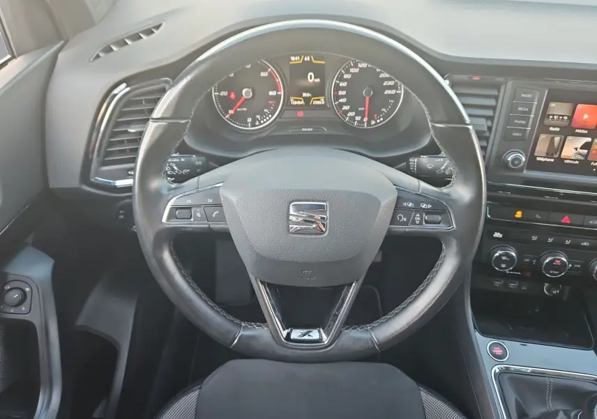 Vue intérieure centrée sur le volant cuir noir et le tableau de bord du SEAT Ateca blanc 2018.