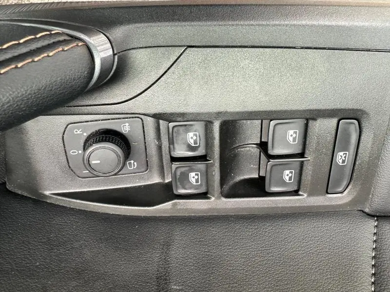 Gros plan sur les commandes des vitres et rétroviseurs côté conducteur du CUPRA Formentor noir Minuit 2024.