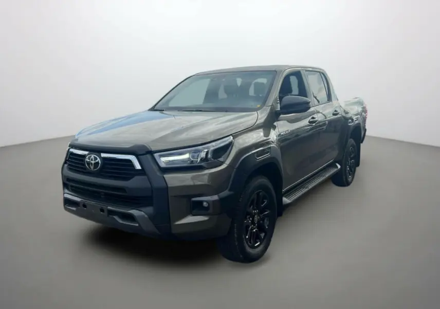 Toyota Hilux 4x4 2025 en bronze impérial, vu en 3/4 avant droit avec jantes noires et calandre marquée.