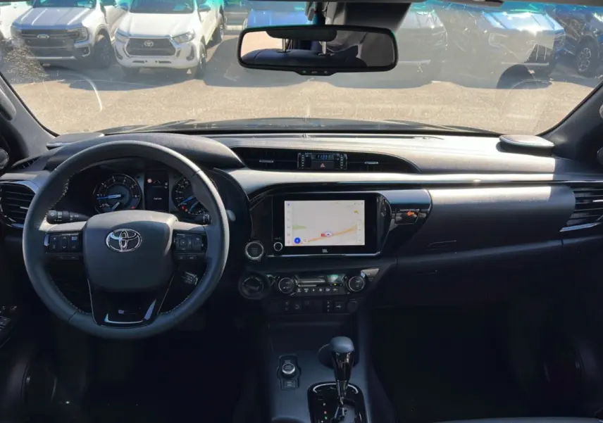 Vue intérieure du tableau de bord du Toyota Hilux 2025 bronze impérial, avec écran tactile et volant multifonction.