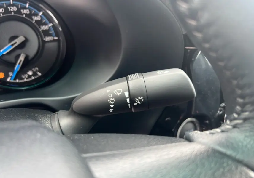 Gros plan sur la commande d'essuie-glace à gauche du volant du Toyota Hilux 2025, tableau de bord partiellement visible.