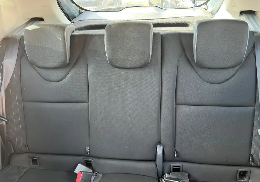 Vue rapprochée du volant en cuir noir de la Renault Clio IV 2019 avec tableau de bord et commandes au volant visibles.