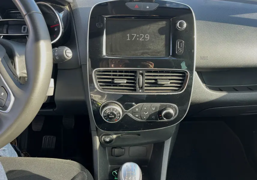 Tableau de bord de Renault Clio IV 2019 avec écran tactile, commandes de climatisation et prises USB visibles en gros plan.