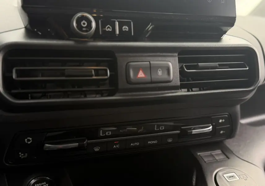 Gros plan sur la console centrale du Peugeot Rifter 2026, montrant les aérateurs et commandes de climatisation.