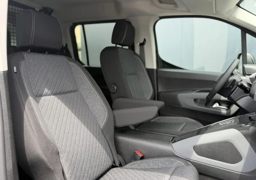 Vue intérieure côté droit du Peugeot Rifter 2026, sièges tissu gris avec accoudoir central déployé.