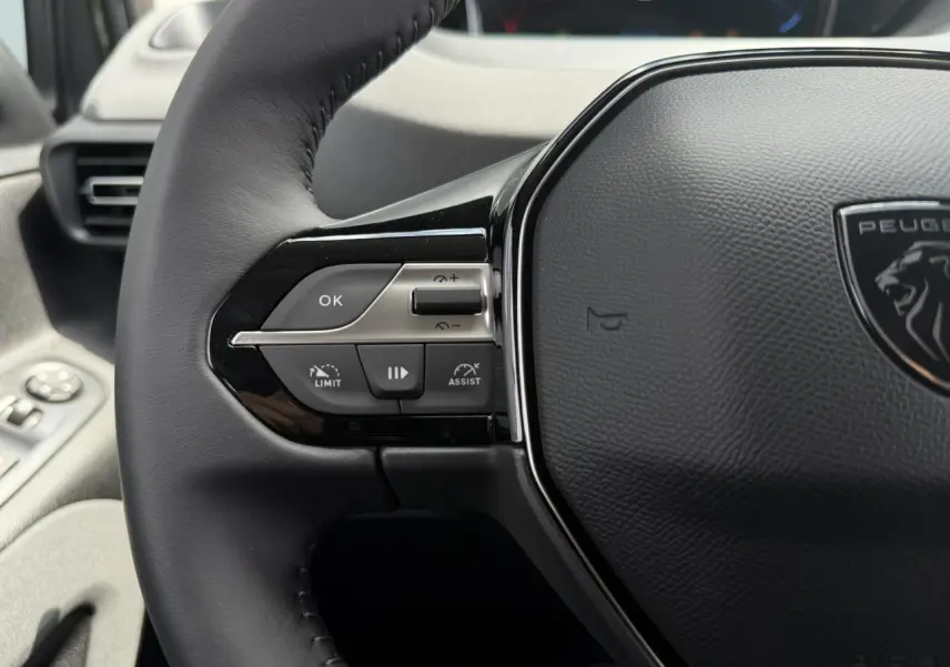 Gros plan sur le volant cuir multifonction du Peugeot Rifter 2026, avec commandes intégrées côté gauche.