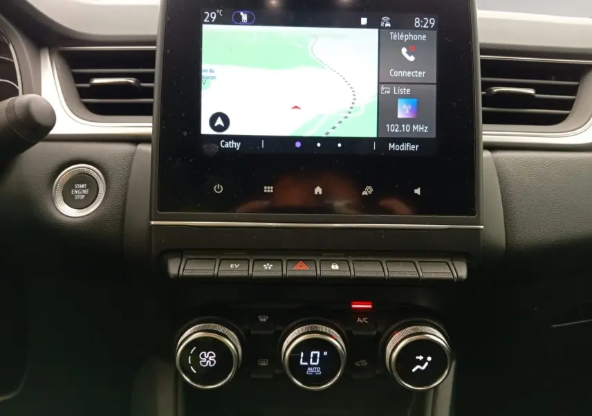 Vue rapprochée de la console centrale du Renault Captur E-Tech 2023, écran tactile et commandes climatisation visibles.