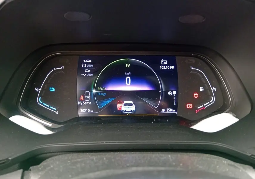 Tableau de bord numérique du Renault Captur E-Tech gris alu/noir, affichant la vitesse à 0 km/h et l'autonomie.