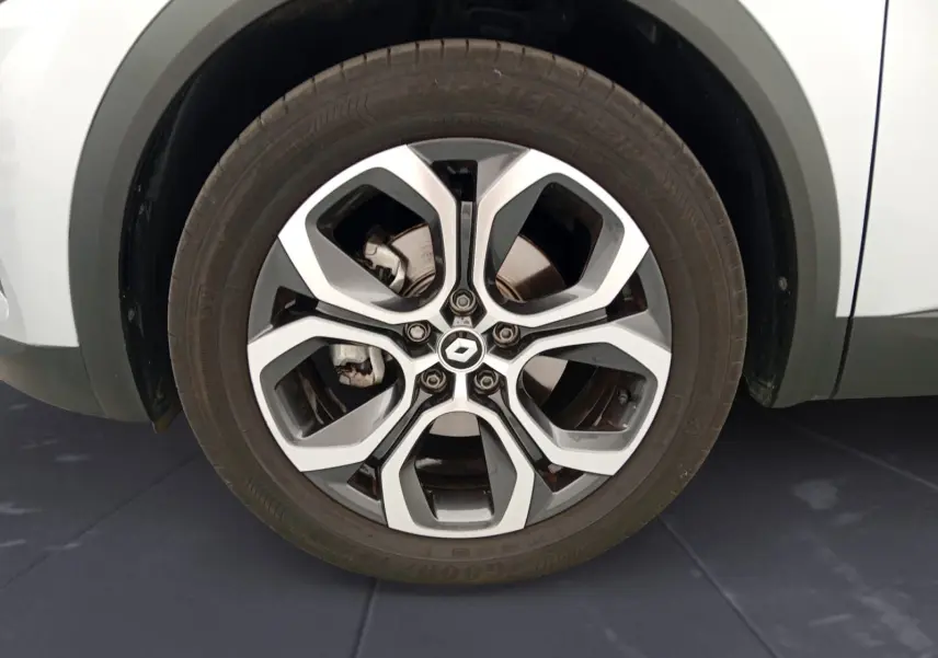 Gros plan sur la roue avant droite du Renault Captur gris alu/noir, mettant en valeur la jante alliage 18 pouces au design moderne.