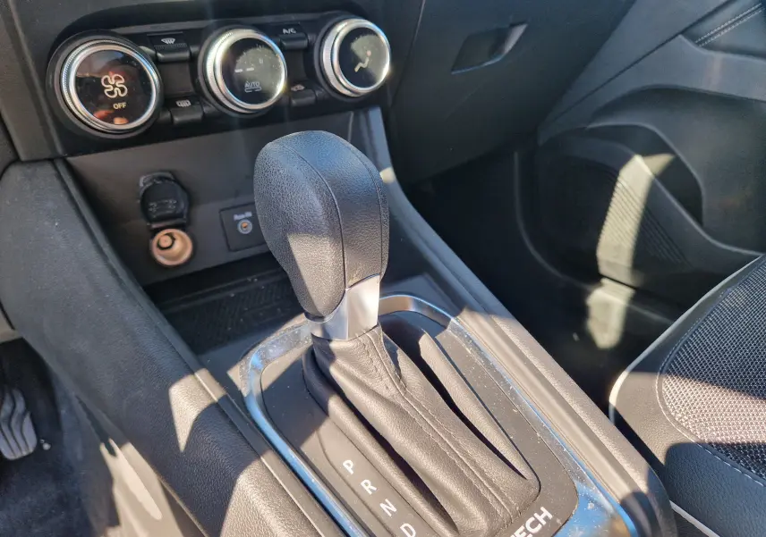 Le levier de vitesse automatique noir du Renault Captur E-Tech 145, avec commandes de climatisation en arrière-plan.