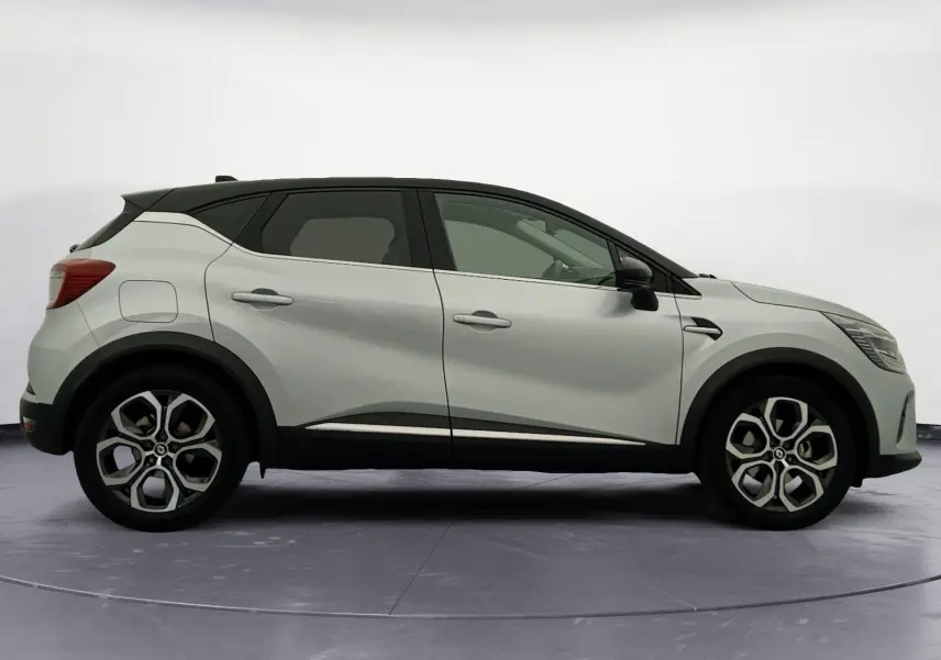 Profil droit du Renault Captur 2023 hybride gris alu avec toit noir et jantes alliage 18 pouces distinctives.
