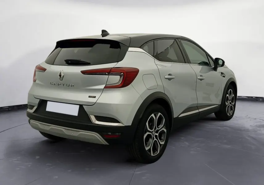 Renault Captur E-Tech Full Hybrid 145 Techno 2023 gris alu/noir, vue 3/4 arrière droit avec toit noir et jantes 18 pouces.