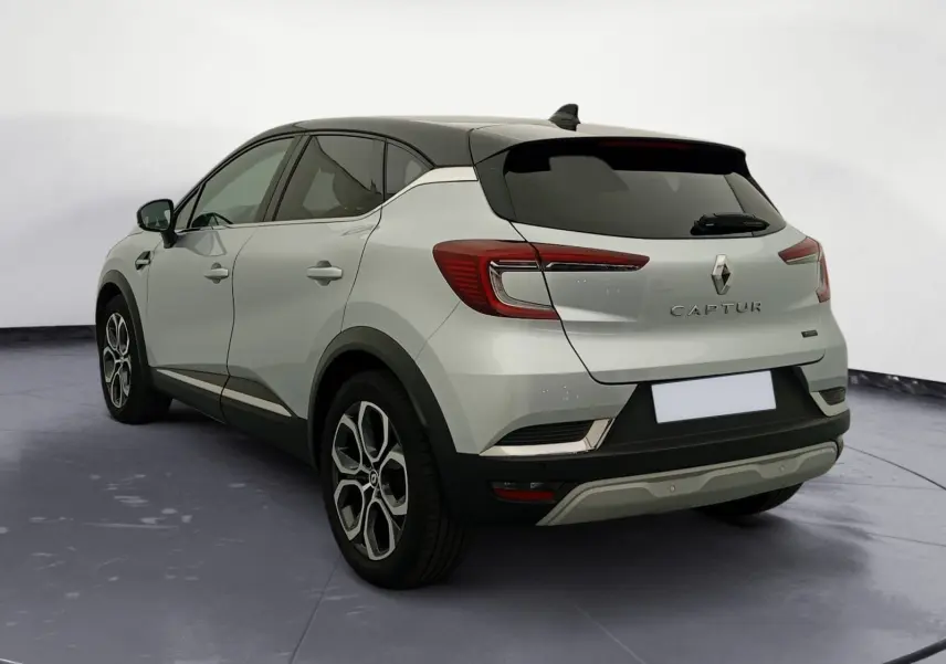 Renault Captur E-Tech Full Hybrid 145 Techno 2023 en gris alu et noir, vue 3/4 arrière avec jantes 18 pouces.