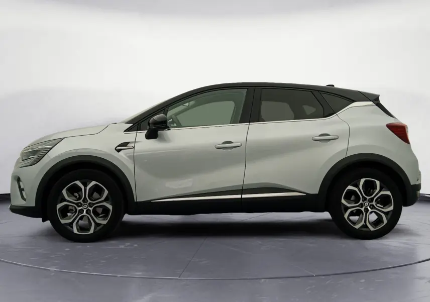 Profil droit du Renault Captur E-Tech Full Hybrid 145 Techno 2023 en gris alu avec toit noir et jantes 18 pouces.